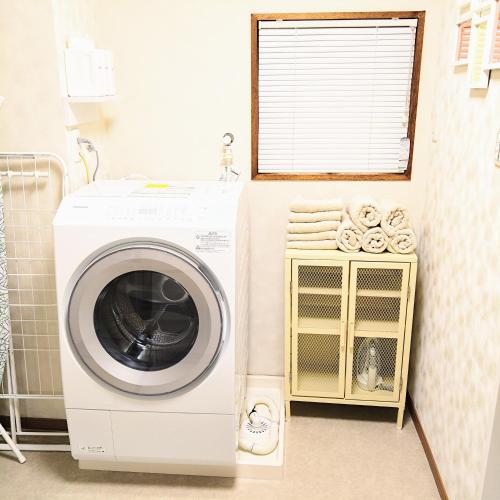 a washing machine in a bathroom with a window at Deep湘南 in Kugenuma