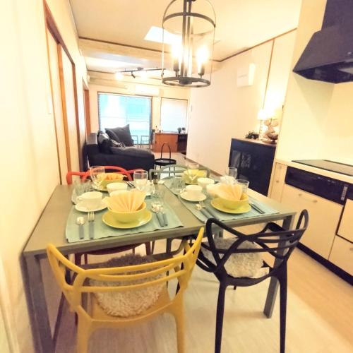 a kitchen with a table and two chairs with plates on it at Deep湘南 in Kugenuma