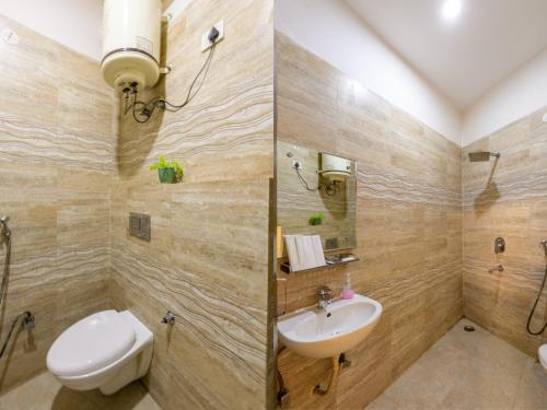 a bathroom with a toilet and a sink at Hotel Apple Tree - Near Mahipalpur Market in New Delhi