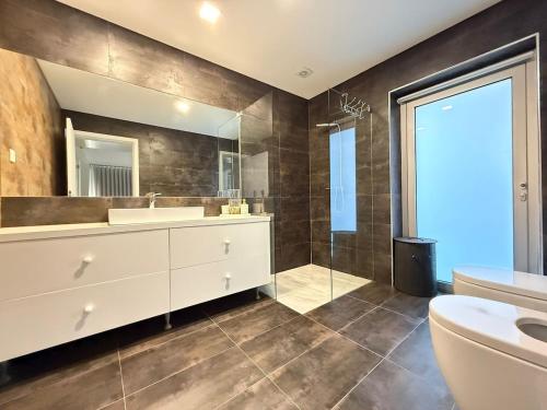 a bathroom with a sink and a toilet and a mirror at Villa Teixugueiras 1 - Gerês in Vieira do Minho