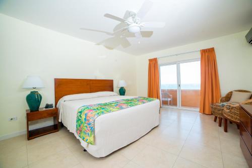 1 dormitorio con 1 cama y ventilador de techo en Sugar Bay Club, en Frigate Bay