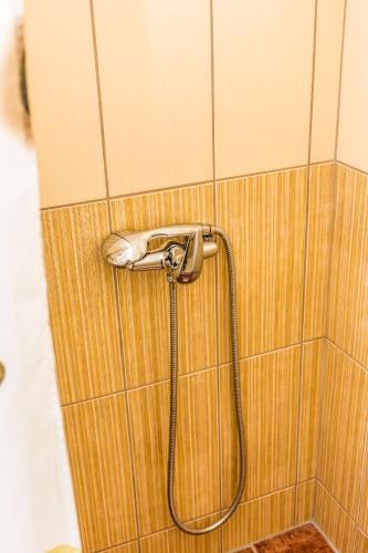 a shower with a hose attached to a wall at Apartmani Kastel in Banja Luka
