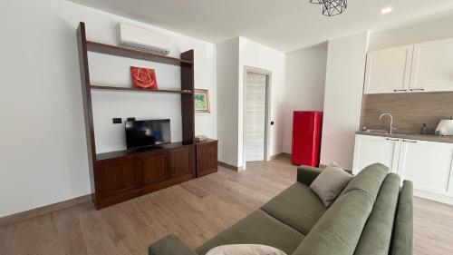 Una sala de estar con un sofá y un televisor de pantalla plana. en Tolstoi 15, en Saronno