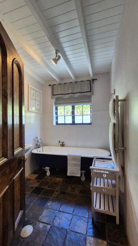 a large bathroom with a tub and a window at Lavender’s Blue in Stanford