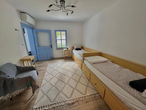 a room with three beds and a blue door at Kökény Kunyhó in Kisszékely