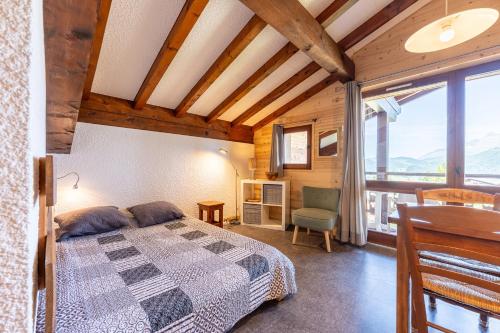a bedroom with a bed and a large window at Studio 18 - Le Chamois in Crest-Voland