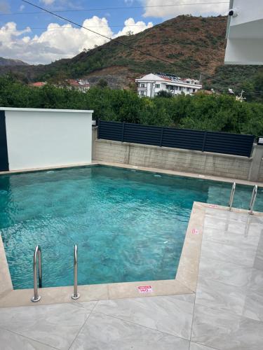 a swimming pool with blue water in front of a building at Mirşah SUİT in Bezkesen