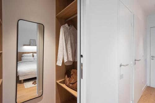 a bedroom with a mirror and a bed at BABEL COMMUNITY Hôtel Saint-Quentin-en-Yvelines in Montigny-le-Bretonneux
