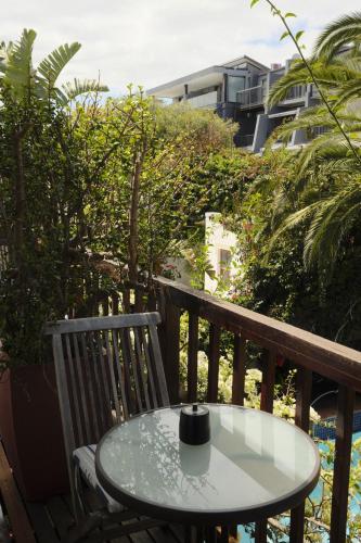 a table and a chair on a balcony at Villa Costa Rose in Cape Town
