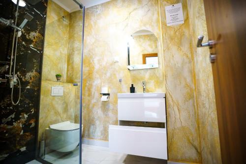 Un baño con lavabo y ducha de cristal. en Hotel Fantazia Oradea - Self Check In & Out, en Oradea