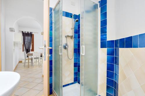 a bathroom with a shower with blue tiles at Residence Orizzonti app n 23 in Golfo Aranci