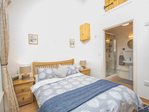 a bedroom with a bed and a bathroom with a shower at 1 Bed in Netherbury DC021 in Netherbury