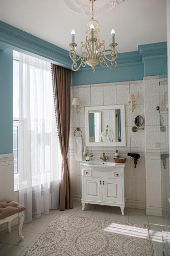 a bathroom with a white sink and a mirror at Royal BV in Ustʼ-Kamenogorsk