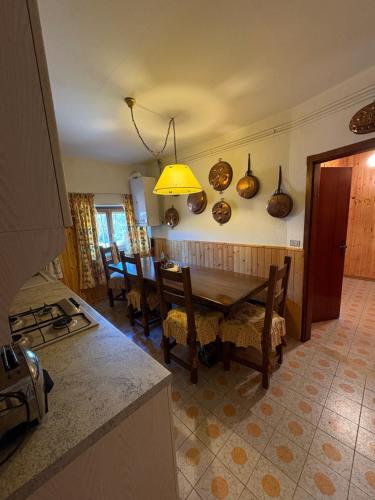 Una cocina y un comedor con mesa y sillas. en Nila's nest, en SantʼAnna Pelago