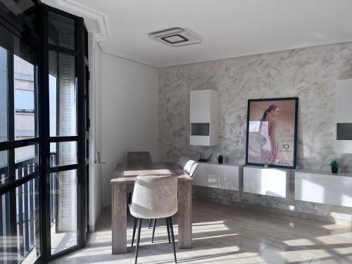 a white room with a table and a chair at Casa Blanca - apartamento en Gandia in Gandía