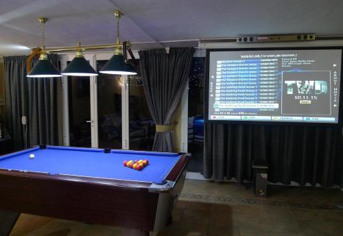 una mesa de billar en una habitación con pantalla en Finca Toledo, en San Miguel de Abona