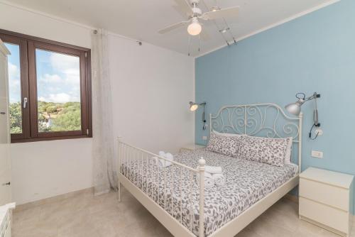 a bedroom with a bed in a room with a window at C 207 Puntavilla - Vista Piscina in La Maddalena