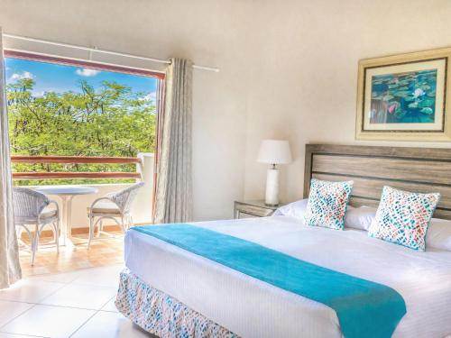 Ένα ή περισσότερα κρεβάτια σε δωμάτιο στο Sugar Cane Club Hotel & Spa