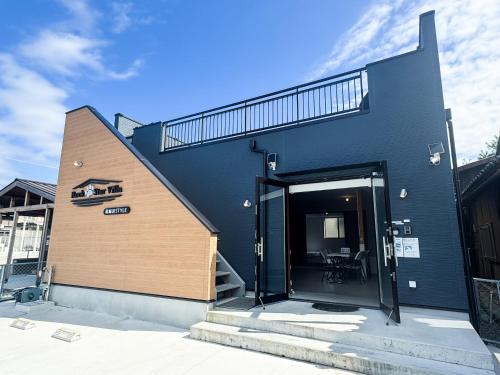 a black building with a staircase on the side of it at Rockstar Villa 尾崎浜STYLE in Awaji