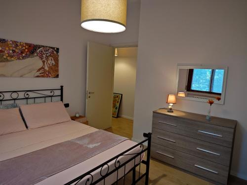 a bedroom with a bed and a dresser with a window at B&b La Lucciola in Salsomaggiore Terme