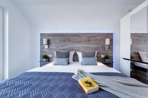a bedroom with a large bed with a book on it at Fewo Kapitän James Cook Olpenitz in Kappeln