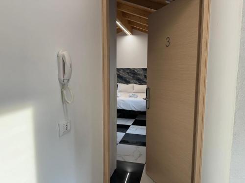 Puerta a una habitación con cama y teléfono en Welc-ōM Celeste Rooms, en Ponte di Brenta