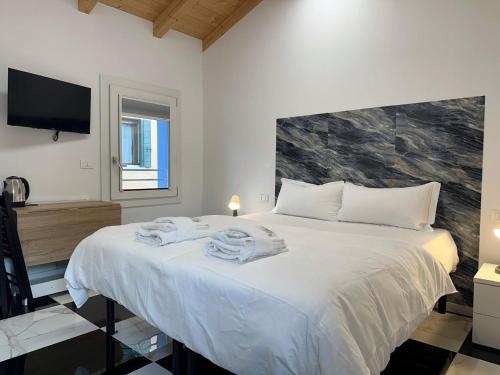 Un dormitorio con una cama grande con toallas. en Welc-ōM Celeste Rooms, en Ponte di Brenta