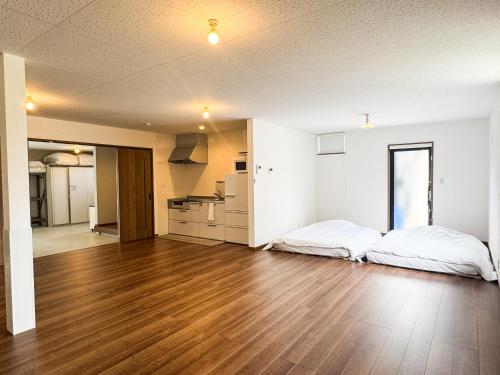 an empty room with two beds and a kitchen at Rockstar Villa 尾崎浜STYLE in Awaji