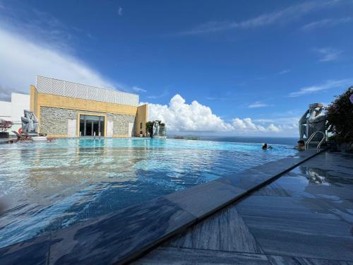 a large swimming pool in front of a building at Min Min Retreat in Phước Hậu