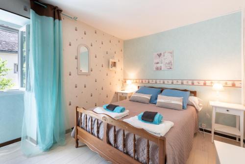 a bedroom with a large bed with blue pillows at Gite Bellevue Accous in Accous