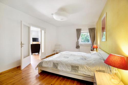 LangballigにあるFerienhaus 'kiek op de Beek'のベッドルーム(ベッド1台、デスク、ランプ付)