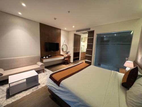 a bedroom with a large bed and a television at Min Min Retreat in Phước Hậu