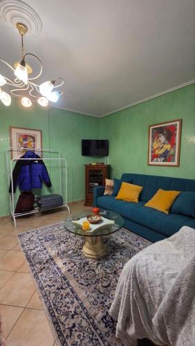 ein Wohnzimmer mit einem blauen Sofa und einem Tisch in der Unterkunft Ari's apartment in Arachova