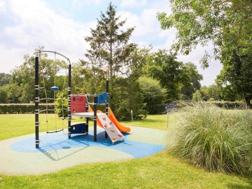 a playground with a slide in a park at Novotel Le Mans in Le Mans