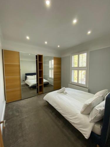 En eller flere senge i et værelse på Stylish 3-Bed Flat Opposite Central Line Station