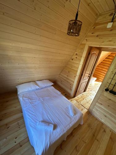 a bedroom with a bed in a wooden room at Borjomi-sadgeri comfort in Borjomi