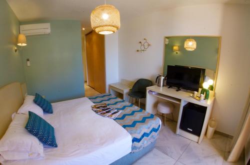 a bedroom with a bed and a desk with a computer at Les Flots Bleus in Porto Ota