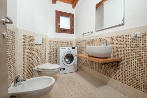 a bathroom with a sink and a washing machine at Residence Orizzonti 33 in Golfo Aranci