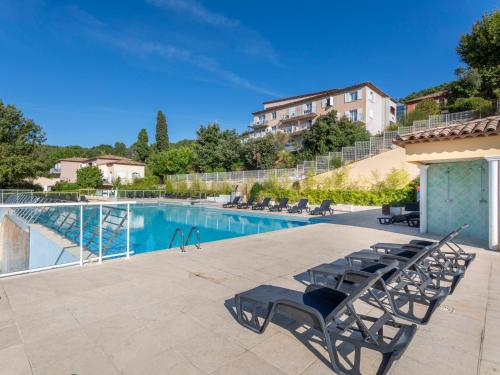 a swimming pool with chairs next to a building at Vacancéole – Le Domaine de Camiole in Callian