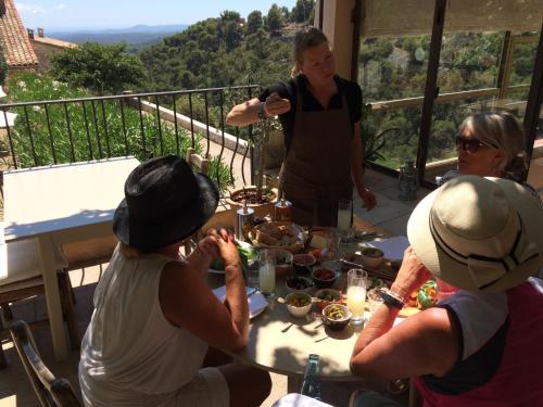 a group of people sitting around a table eating food at Auberge De Tourrettes in Tourrettes-sur-Loup