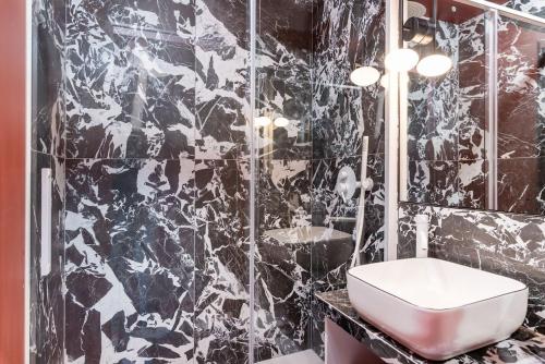 ein schwarzweißes Bad mit einem Waschbecken und einem WC in der Unterkunft Suite de charme-Expérience unique et raffinée in Lyon