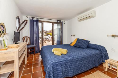 a bedroom with a bed and a table and a desk at Alojamiento con encanto in Binibeca