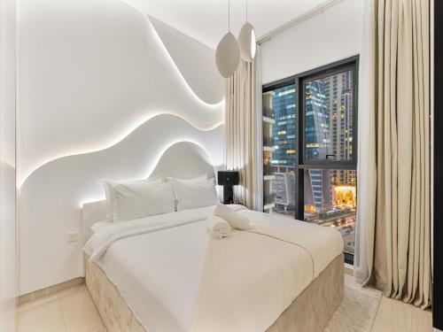 a bedroom with a white bed and a large window at Luxurious Escape - ZADA TOWER - Close to Dubai Mall & Burj Khalifa in Dubai