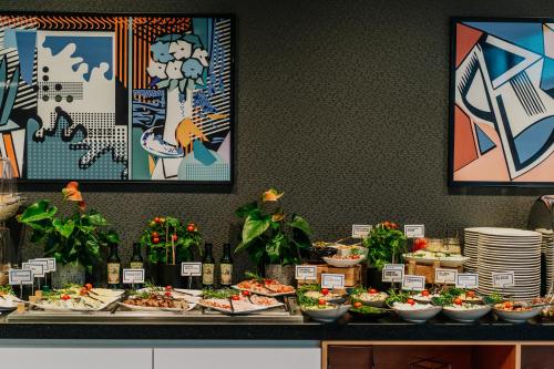 a buffet with many plates of food on a table at Q Hotel Kraków in Kraków