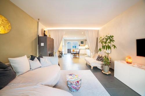 sala de estar con sofás blancos y TV en Lieblingsplatzl, en Naturno