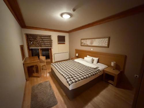 une chambre avec un lit, une table et une chaise dans l'établissement Jahorina Apartmani Vučko F&F, à Jahorina
