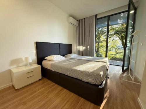 a bedroom with a large bed and a window at Villa Teixugueiras 2 - Gerês in Vieira do Minho