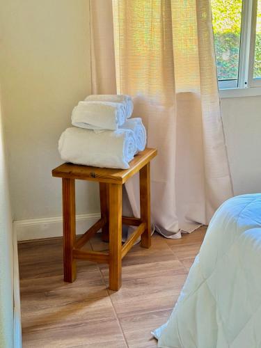 a pile of towels on a table next to a bed at Vina in Villa Elisa