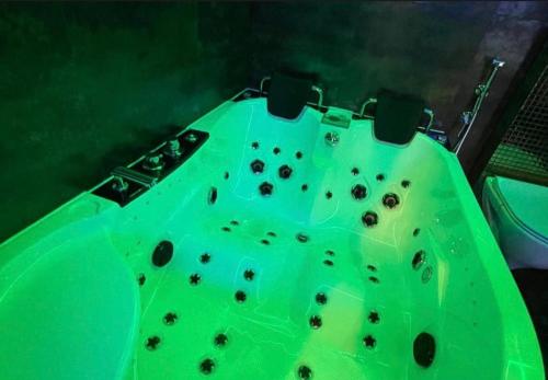 a green bathtub with a bunch of rocks on it at Gold Glass z Jacuzzi &Sauną Rynek Centrum in Kielce