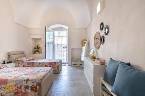 a bedroom with two beds and a window at La dimora di Sole in Ostuni